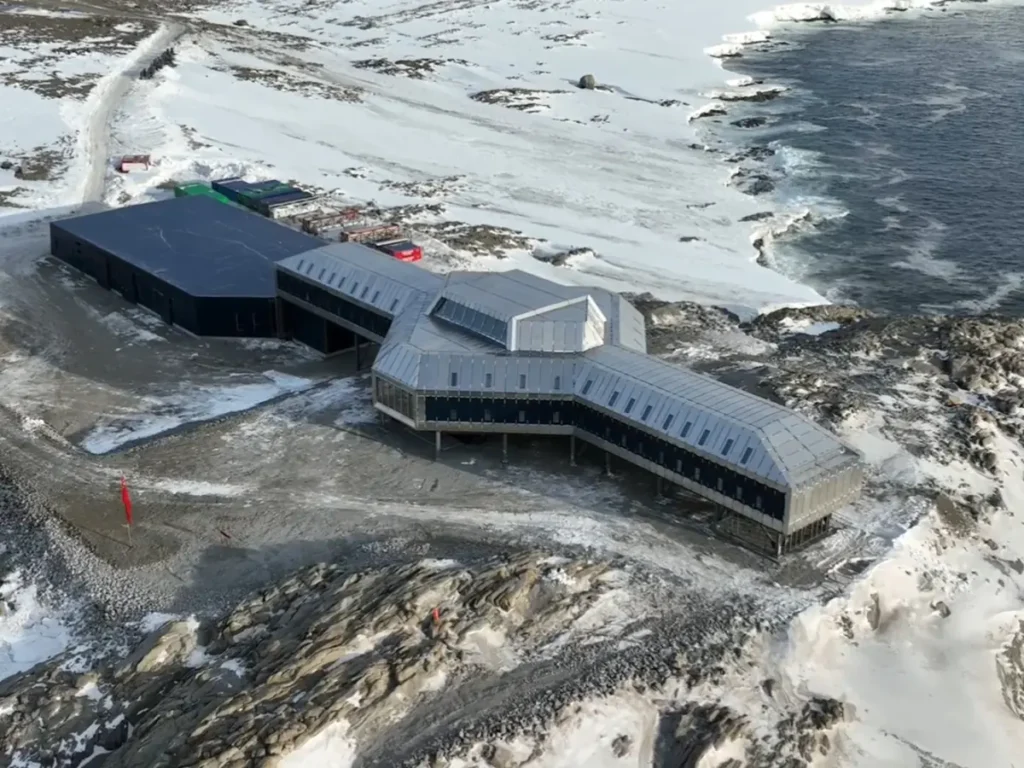 Vista exterior de la base antártica china Qinling en la costa del Mar de Ross, mostrando su diseño modular moderno y torres de comunicación.